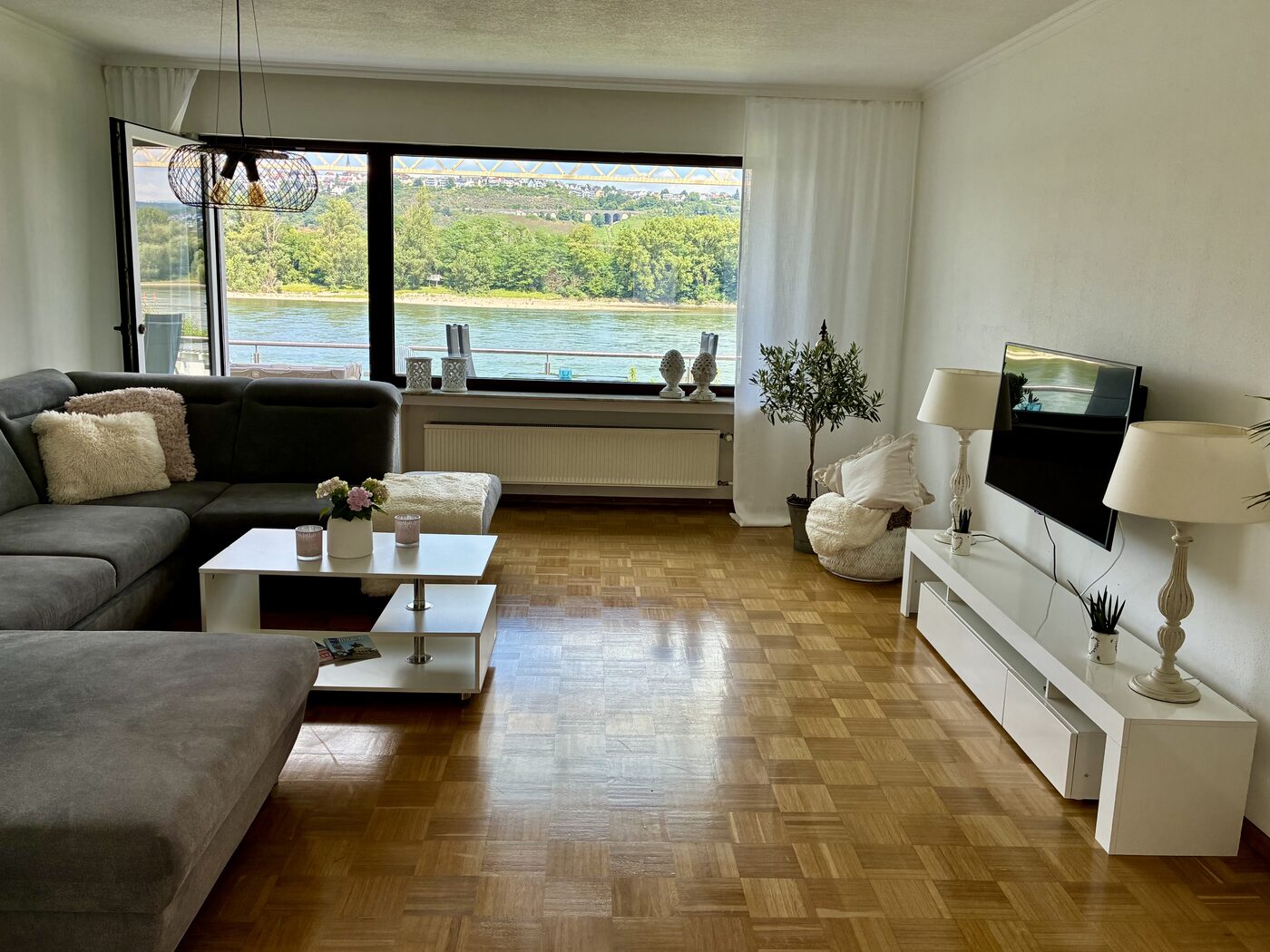 Wohnzimmer mit großem Panoramafenster zum Rhein