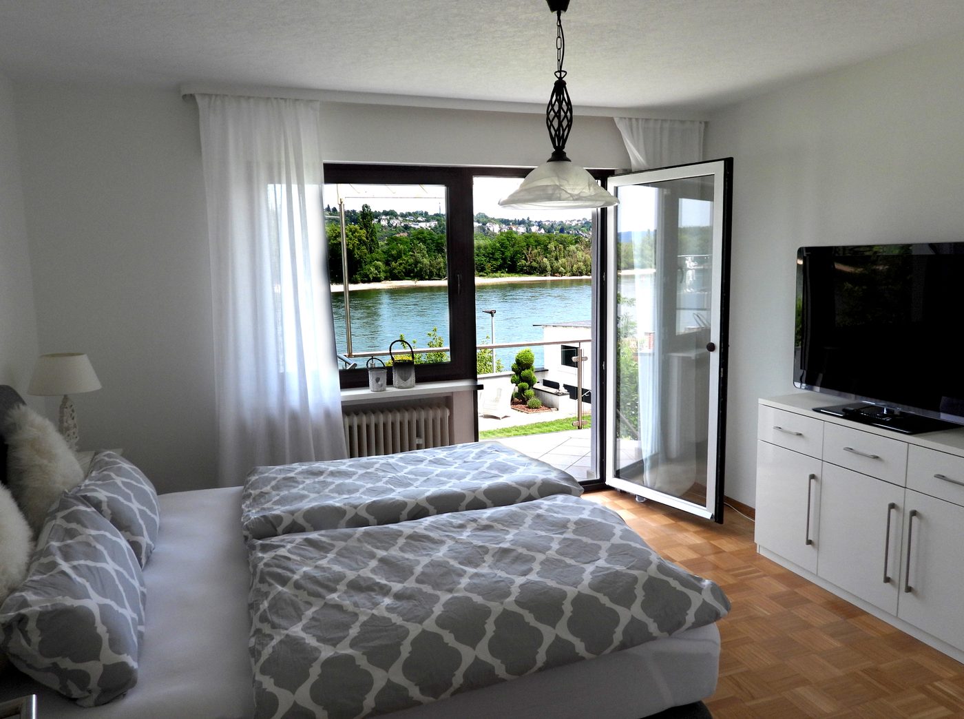 Schlafzimmer 1 mit Doppelbett, Balkontür und Blick auf den Rhein